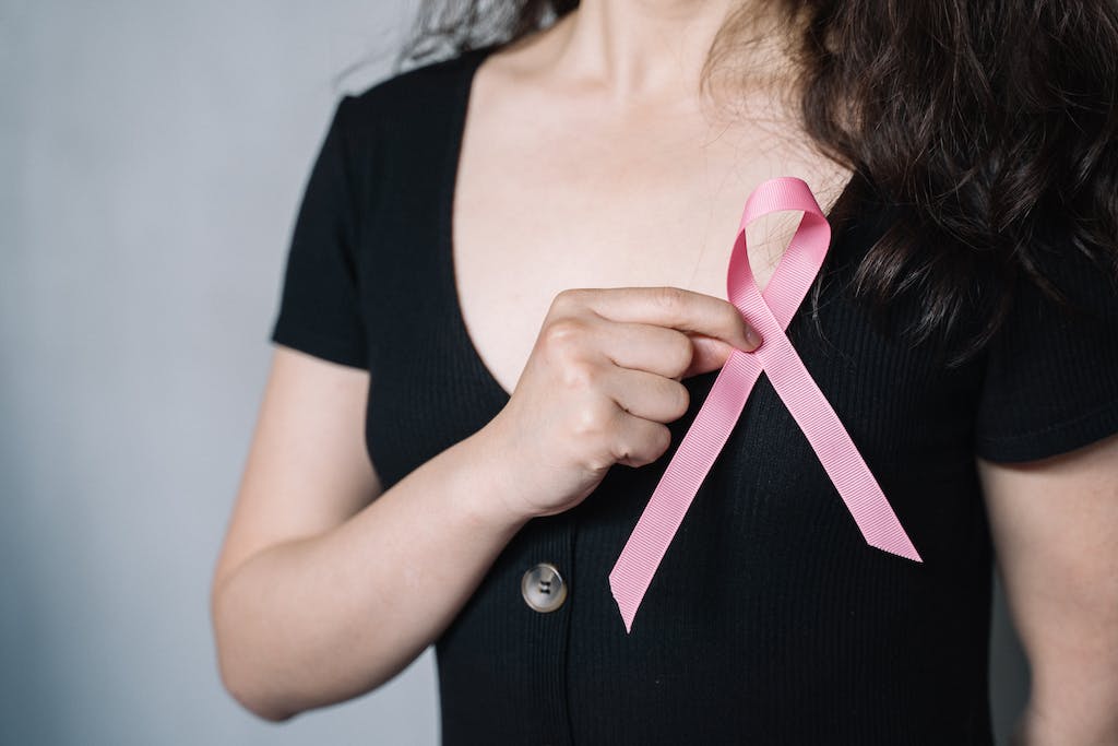 Woman Holding Pink Ribbon as a Cancer Coach and patient